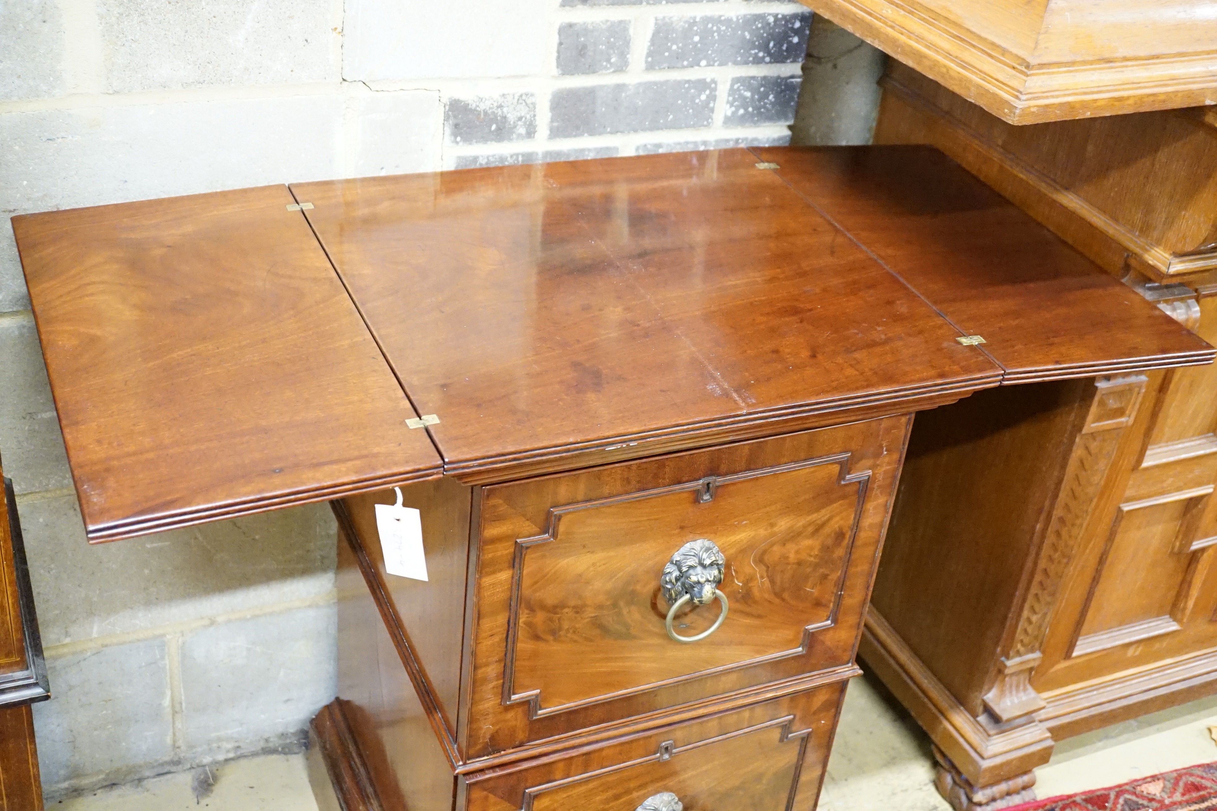 A George III mahogany pedestal designed by C. Wilson, with twin flap top, cellaret drawer now with two decanters and base cupboard, width 53cm, height 87cm